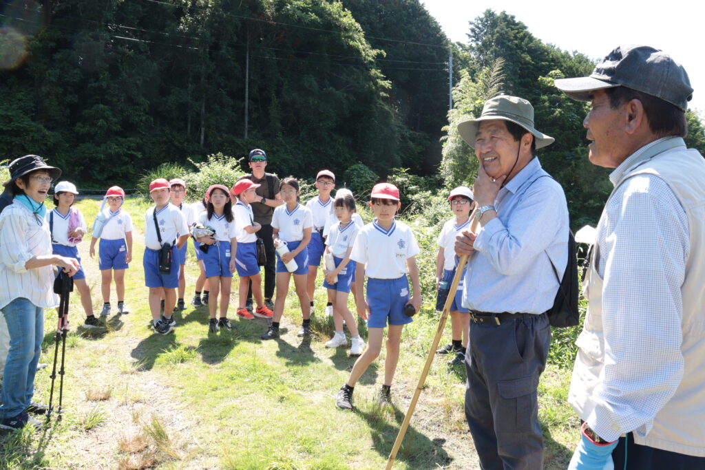 前原理事長らの話を聞く児童