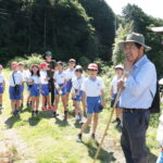 前原理事長らの話を聞く児童