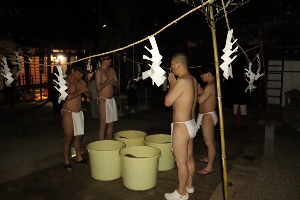 経を唱え水行に臨む参加者