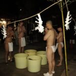 経を唱え水行に臨む参加者