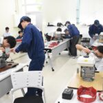 エンジンの組み立てと分解に取り組む中学生たち=岡山県津山市で