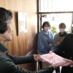 孫心弁当を高齢者に手渡す生徒