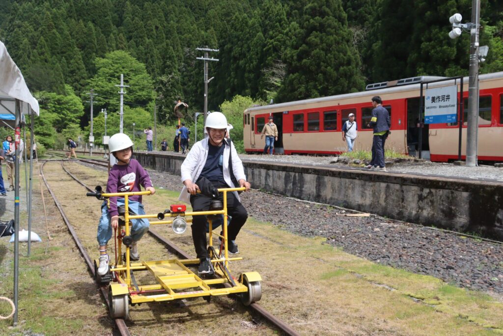 軌道自転車の運転を楽しむ乗客たち=美作河井駅で