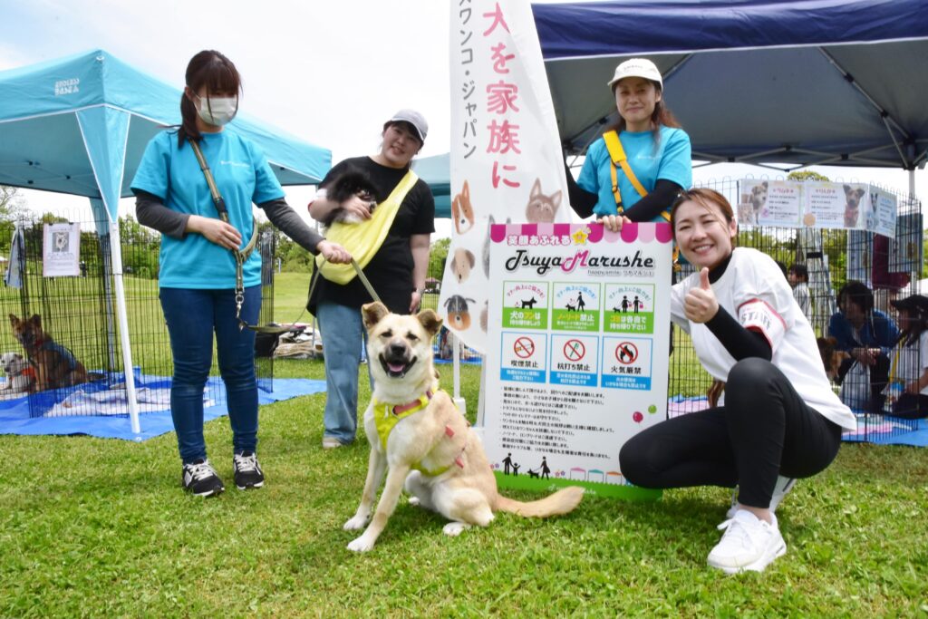 実行委の木元さん（左から二番目）と森富さん（右）、ピースワンコブース前で