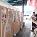 じっくりとポスターを観賞し、お気に入りを決める買い物客＝岡山県津山市で