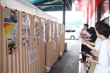 じっくりとポスターを観賞し、お気に入りを決める買い物客＝岡山県津山市で