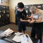 介助してもらいながら入浴準備をするお年寄り