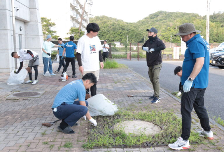 ひまわりドーム前の雑草を取る同商工会青年部メンバー＝岡山県美作市で