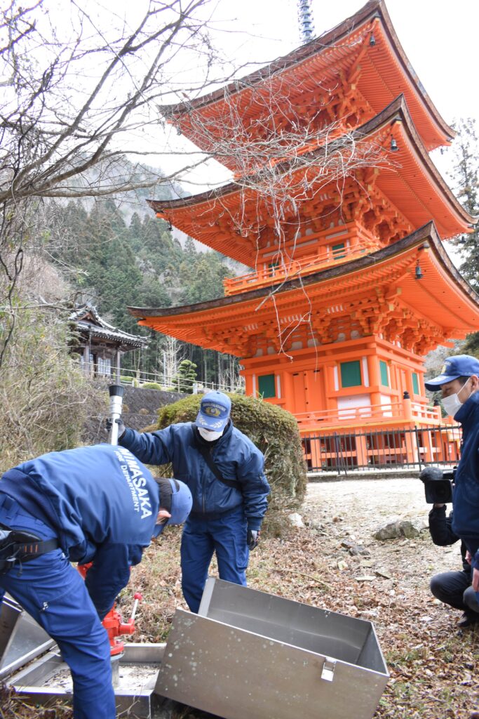 長福寺三重塔で防火設備を確かめる署員＝岡山県美作市にて