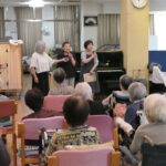 参加者の前であいさつする赤堀さん（中央）