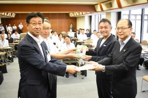 著者の稲葉さん（右から２人目）も出席し、松岡理事長（右）から有本教育長へ目録の贈呈