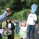 捕まえた昆虫を観察する参加者=岡山県奈義町で