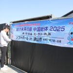 手際良く横断幕を設置するスポーツ課の職員=岡山県津山市で