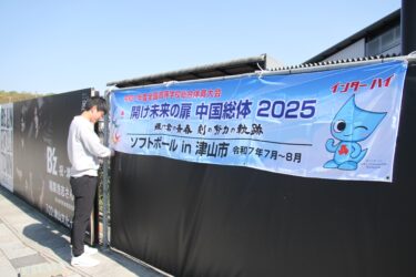 手際良く横断幕を設置するスポーツ課の職員=岡山県津山市で