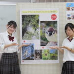 入賞作品をバックに笑顔を見せる本田さん（左）と邑久さん＝岡山県津山市で