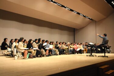 藤岡さんの指導を受ける合唱団=岡山県津山市で