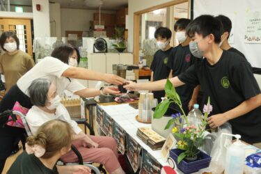 認知症の高齢者らに笑顔でコーヒーを提供する生徒たち=岡山県津山市で