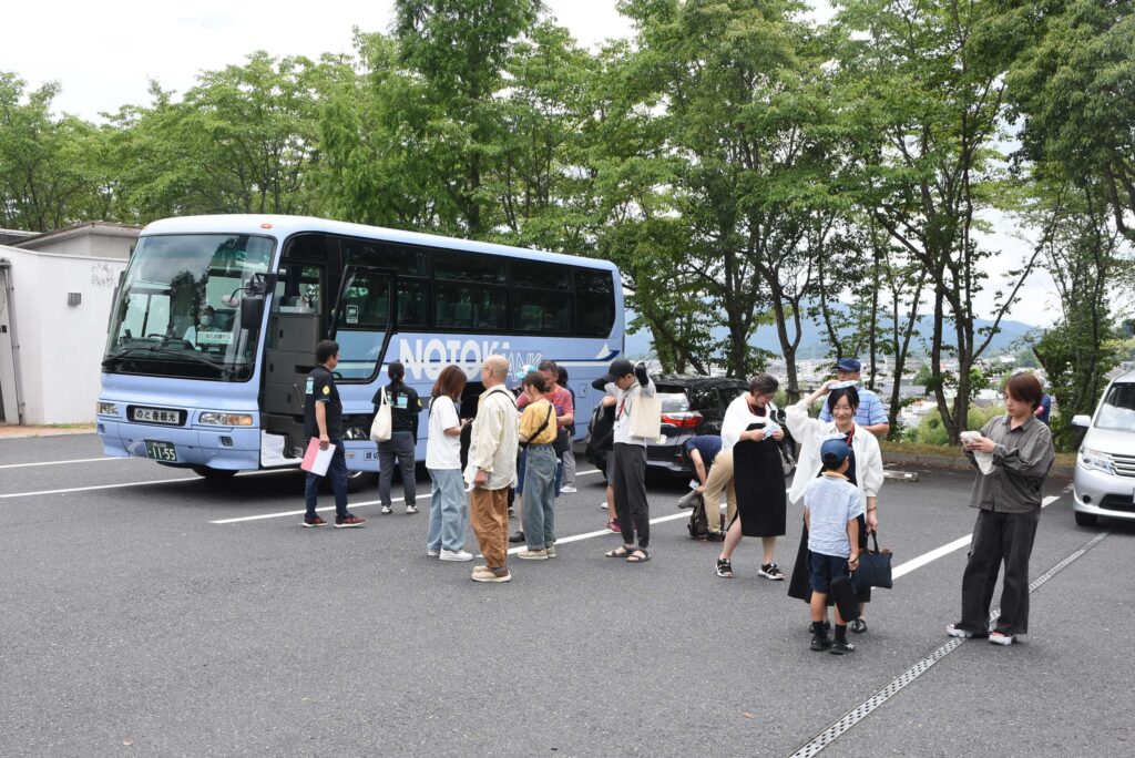 バスから降りる参加者=大田のリージョンセンターで