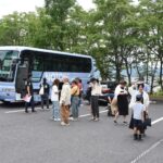 バスから降りる参加者＝大田のリージョンセンターで