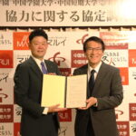 協定を交わした松田社長（左）と加賀学長＝岡山県津山市で