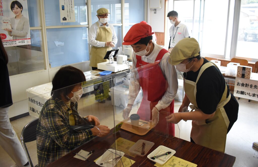 来店客にコーヒーを手渡す生徒