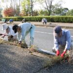 歩道で草取りなどの清掃奉仕をする会員たち=岡山県津山市で