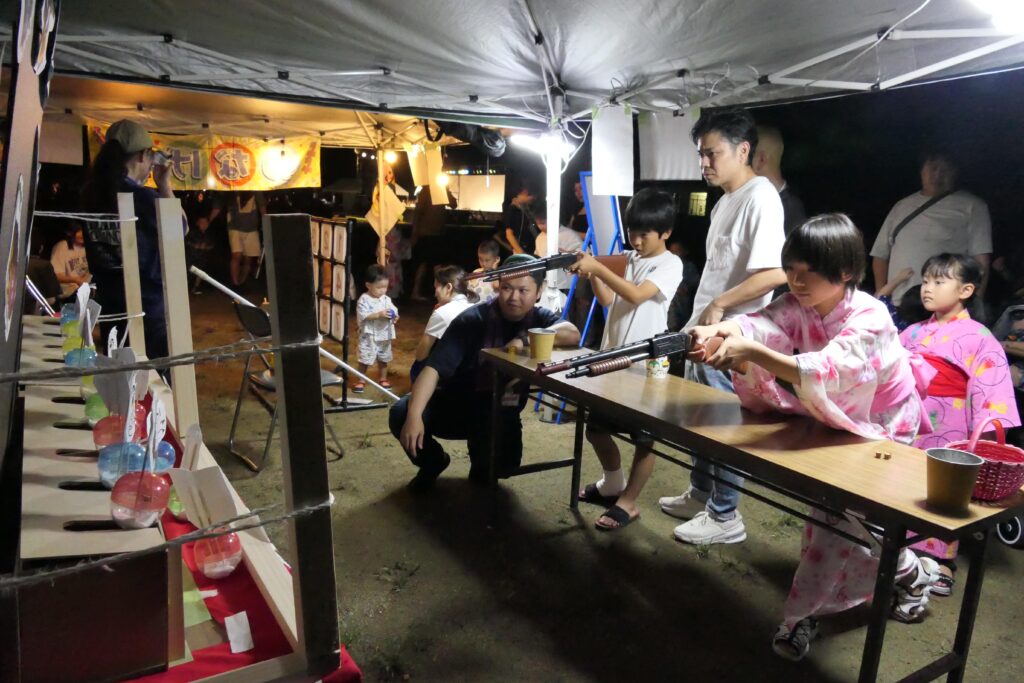 射的で遊ぶ子どもら