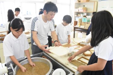 上田さんに教わって紙漉きを体験する子どもたち=岡山県津山市で