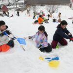 雪でかまくらをつくる子どもたち