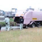 集めた雑草をパッカー車に入れる参加者