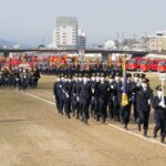 入場行進をする消防組合員と消防団員たち