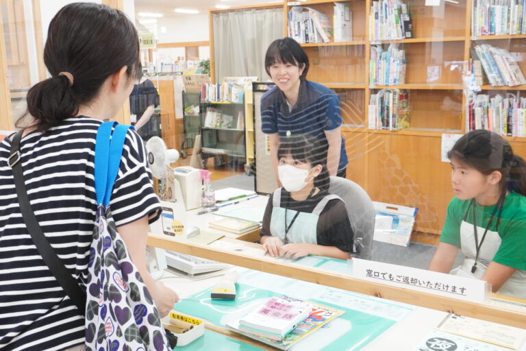 窓口で対応する一日図書館員の子どもたち=岡山県津山市で