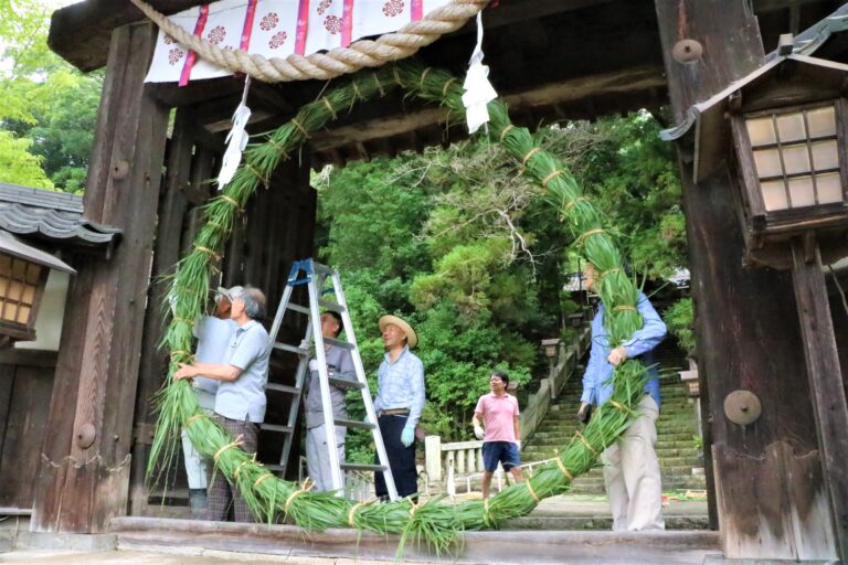夏越祭の茅の輪を神門に据え付ける氏子ら=岡山県津山市で