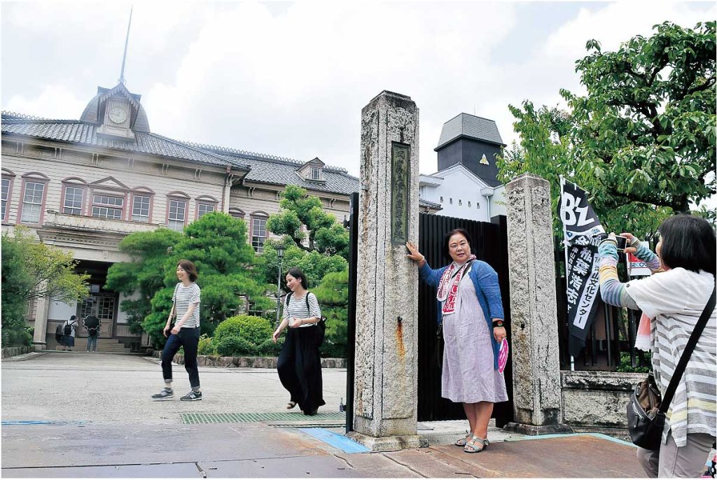 稲葉さんの母校・津山高校の旧本館前で記念撮影を楽しむファン