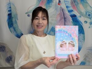 出版された絵本『ふたごの天使』を手にする須田さん=岡山県津山市で