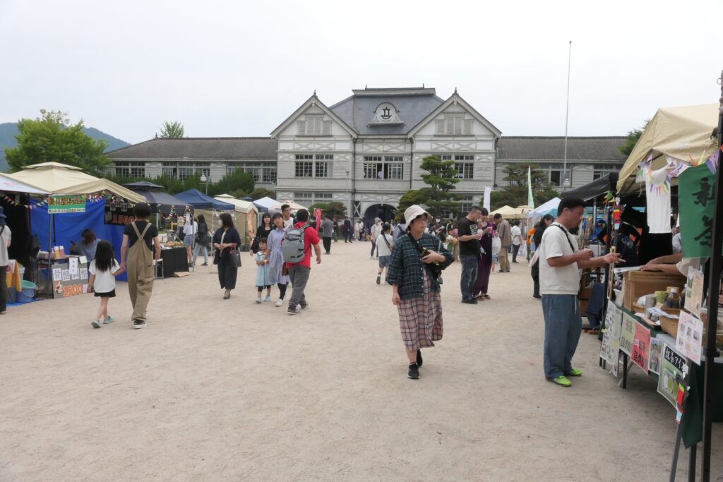 大勢の市民らでにぎわうマルシェ会場=旧遷喬尋常小学校前で