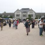 大勢の市民らでにぎわうマルシェ会場＝旧遷喬尋常小学校前で