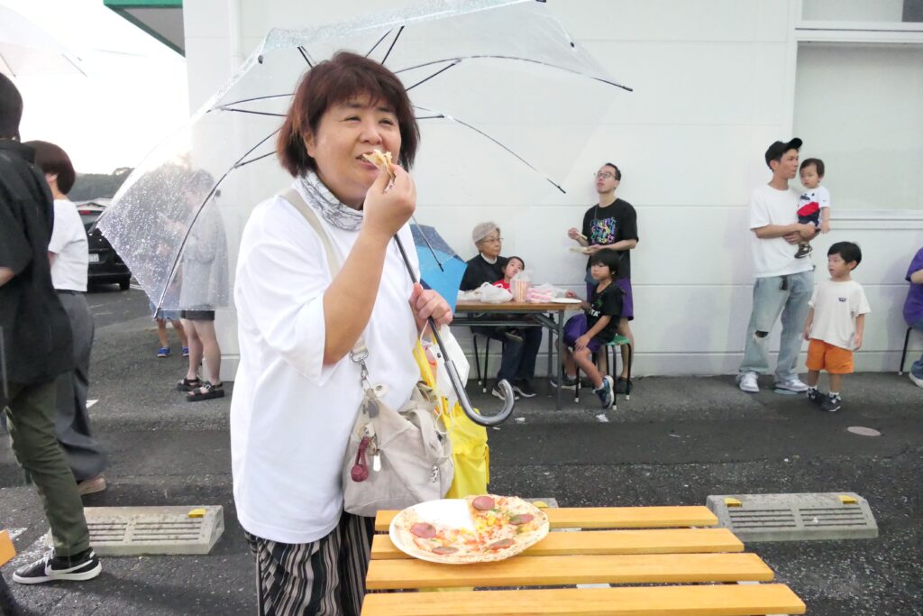 購入したピザを食べる来場者