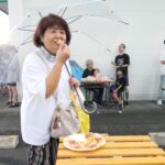 購入したピザを食べる来場者