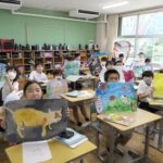 夏休みの宿題に描いた作品を掲げる5年生＝岡山県津山市、加茂小で
