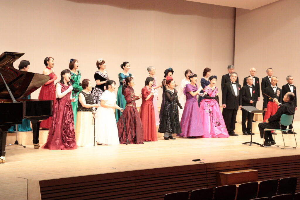 華やかな衣装で歌声を響かせる津山市民コール「アンダンテ」の出演者