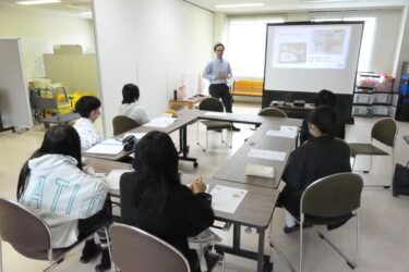 お年寄りを喜ばせようと職員と話し合う生徒たち=岡山県美作市で