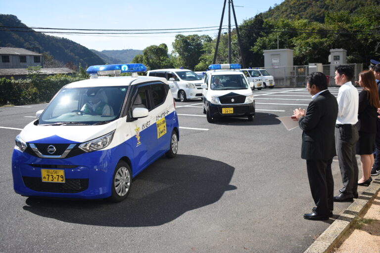 地域安全運動に出発する青パトなど=岡山県美作市で