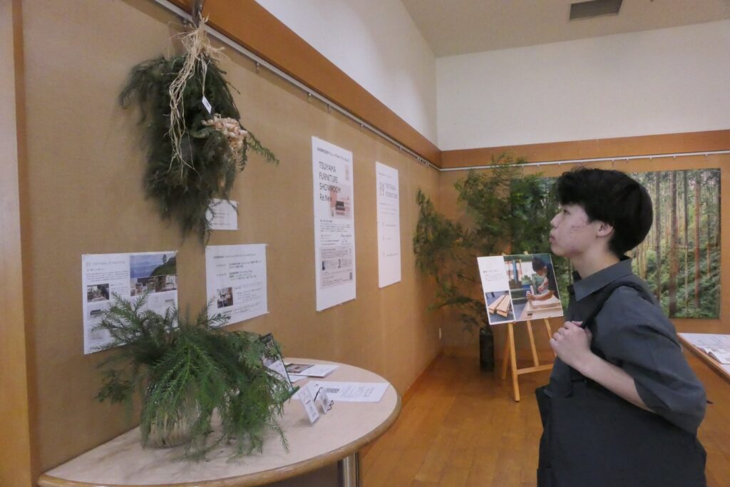 壁飾りなどの展示品を観賞する来館者
