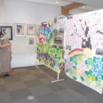 会場に展示された作品を楽しむ来館者＝岡山県真庭市の落合総合センターで