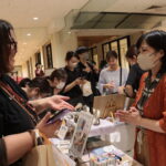 猫をテーマにした商品を前に会話を弾ませる店員と来場者