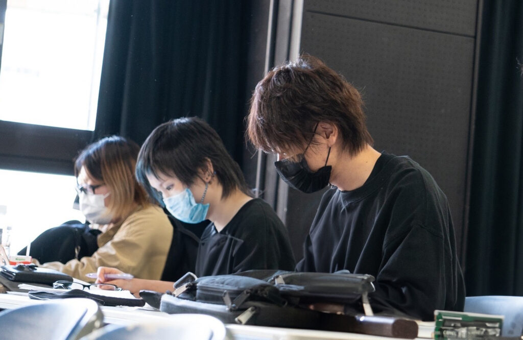 公演に向けて真剣な表情で脚本を確認する小郷拓真さん(右)
