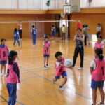 選手と一緒に円陣パスに挑戦する児童＝岡山県真庭市で