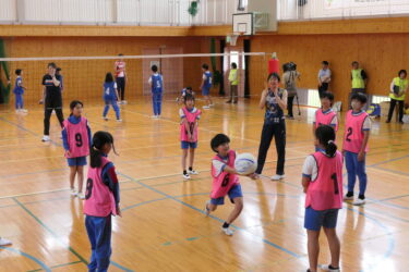 選手と一緒に円陣パスに挑戦する児童＝岡山県真庭市で