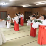 指導を受けながら巫女舞の練習に励む参加者＝岡山県津山市で
